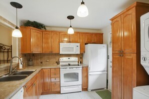 Renovated kitchen with solid surface counter tops, new cabinetry and appliances
