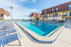 Expansive heated pool surrounded by lounge chairs for the perfect beachside retreat.