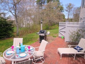 View of the patio with a gas grill, outdoor shower, and yard - 30 Cockle Cove Road Chatham Cape Cod New England Vacation Rentals