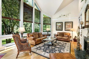 Main living space with ceiling to floor picture windows and vaulted ceilings.