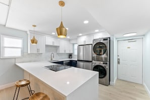 Contemporary kitchen with sleek countertops, and stainless steel appliances