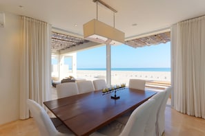 The dining table features ocean views & slidable doors to feel the ocean breeze.