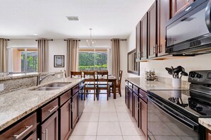 Upgraded and fully stocked kitchen with granite counters