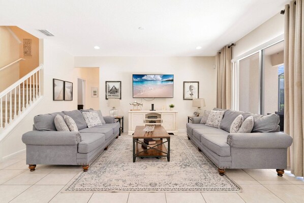 Bright and inviting living room with access to the kitchen and dining rooms and the private pool
