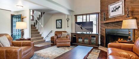 Inviting living room with gas fireplace, flat screen smart TV and access to the master bedroom upstairs and bedrooms 2 & 3 and laundry downstairs.