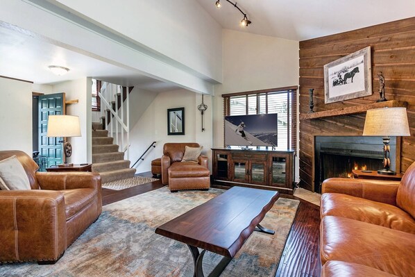 Inviting living room with gas fireplace, flat screen smart TV and access to the master bedroom upstairs and bedrooms 2 & 3 and laundry downstairs.