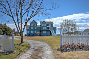 The white picket fence and beautiful trees lead the way to this seaside oasis.