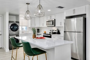Modern kitchen with sleek white cabinetry, quartz countertops, and stylish pendant lighting.