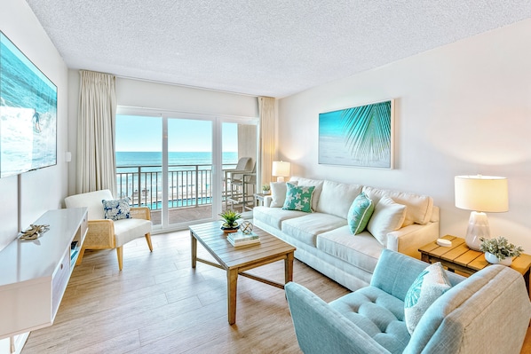 A stunning oceanfront living space with comfortable seating, and direct access to the balcony with breathtaking views.