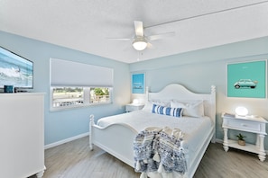 A cozy bedroom with king size bed and large windows that bring in natural light and stunning outdoor views.