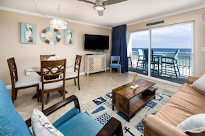 Gulf front living room of Unit 410 - Offering incredible views daily, just open the curtains! Enjoy the recliner while you watch your favorite show.