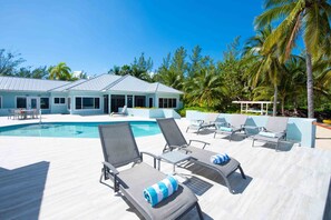 Expansive pool deck with sun loungers.