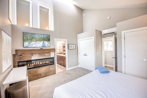 Luxurious Primary Suite with California King Bed, Fireplace, Smart TV, En Suite Bathroom, and Vaulted Ceilings