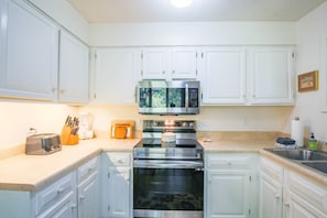 The bright kitchen features new stainless steel appliances.