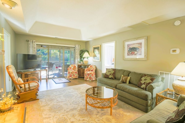 Relax & unwind in this comfortable living room with screened-in porch overlooking the inlet!