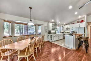 Seat the entire group at the large and functional kitchen table for 10