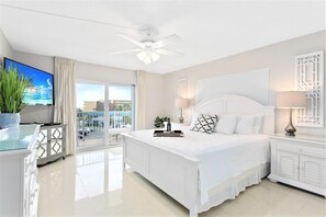 Serene master bedroom featuring a plush king-size memory foam mattress, a flatscreen TV, and private balcony access.