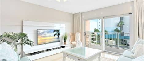 Spacious living room with 60" LCD TV, walks out onto massive private balcony with view of the ocean