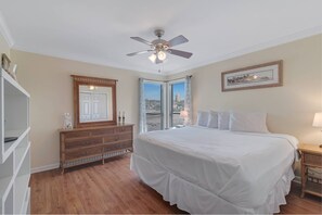 Primary bedroom with king bed, large dresser with mirror, dual nightstands, and private bath.