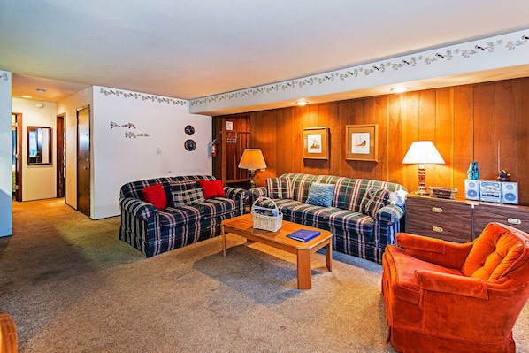 Living room w/ sofa sleeper, TV, DVD player, wood burning fireplace