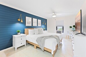Serene and spacious master bedroom with a king bed, ensuite, large TV, and walk-in closet.