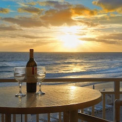 Enjoy a romantic sunset with a glass of wine on your private balcony overlooking the ocean.