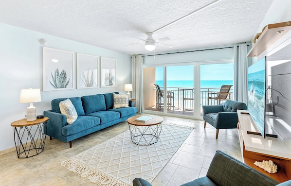 Stunning oceanfront living room with modern coastal decor, large windows, and breathtaking views.