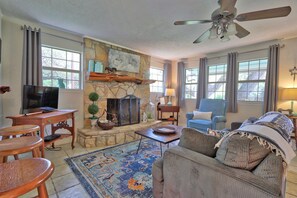 Wood burning fireplace in the living area with lots of natural light.