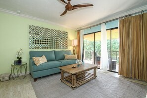 Beautifully decorated living space with queen sleeper sofa & ceiling fan.
