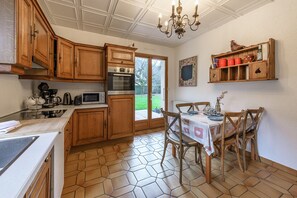 Cuisine équipée avec espace repas et accès sur le jardin 