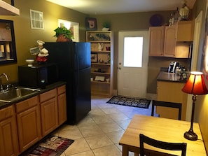 Another view of entry with full size fridge, microwave, and sink.  