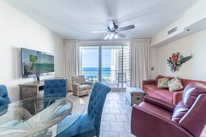 The tropically decorated great room has a queen sleeper sofa with a gel mattress and a comfy leather recliner.