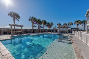 Glistening sun with beautiful Palm trees surrounding Padre Beach View heated pool