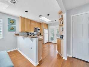 Bright and Airy Kitchen With French Doors Leading To Patio Sitting Area