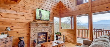 Stunning views inside and out - A double-height windowed wall lets you gaze out at Mount LeConte even as you’re warming up in front of the great room’s stacked-stone fireplace.