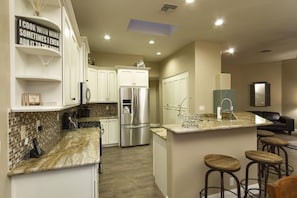 Kitchen has a skylight, solid granite counters, breakfast bar and a french door refrigerator with a water and ice dispenser.