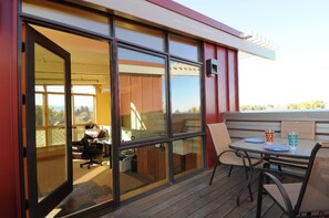 Top level deck with outdoors seating in the summer and a hot tub.