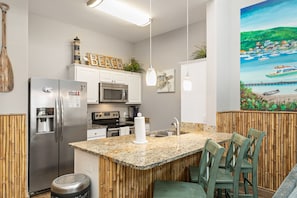 Fully equipped kitchen with breakfast bar that seats three