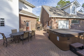 Back patio with dining table and hot tub