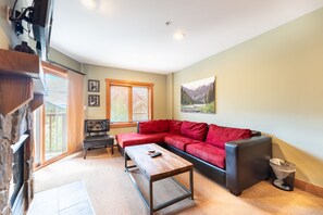 Living area with mounted flat screen TV, gas fireplace and access to the private balcony.