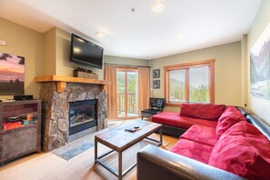 Living area with mounted flat screen TV, gas fireplace and access to the private balcony.
