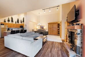 Spacious living room with a mounted TV, gas fireplace, queen sleeper sofa, and queen Murphy bed.