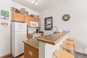Full kitchen with breakfast bar seating up to 4.