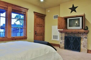 Living room/bedroom of lookout cabin with TV and fireplace