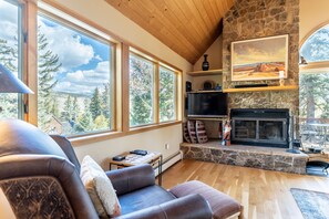 Living area featuring new cozy furnishings and a wood-burning fireplace.