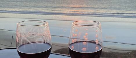 Two glasses of wine on a table overlooking the Pacific Ocean