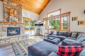 Gorgeous Stone Face Fire Place in the Great Room that is Well Lighted by Wide Glass Window