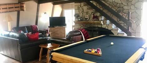 Charming living room with pool table and fireplace