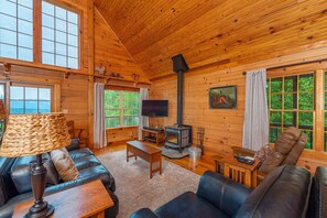 Gather in the great room with floor-to-ceiling views around the wood-burning stove
