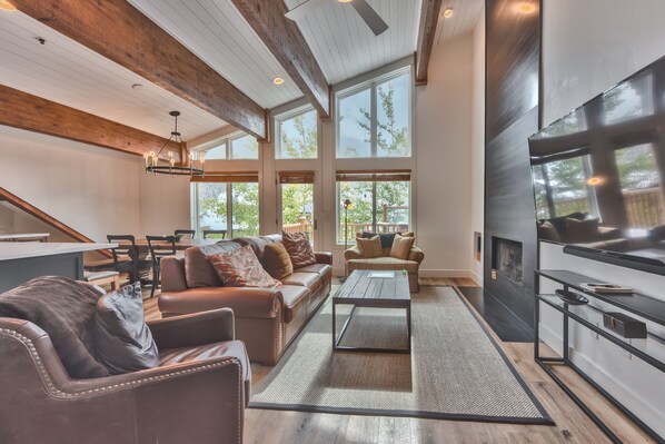 Living Room with a Gas Fireplace, a 70" Sony Smart TV, and Queen Sofa Sleeper. Windows from Floor to Ceiling with Amazing Views of Deer Valley Resort